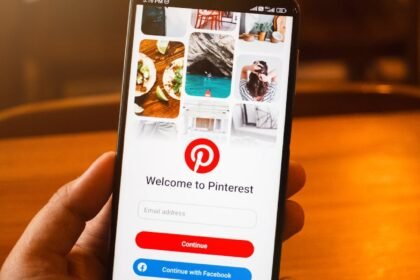 a person holding up a smartphone with the pinterest app on it