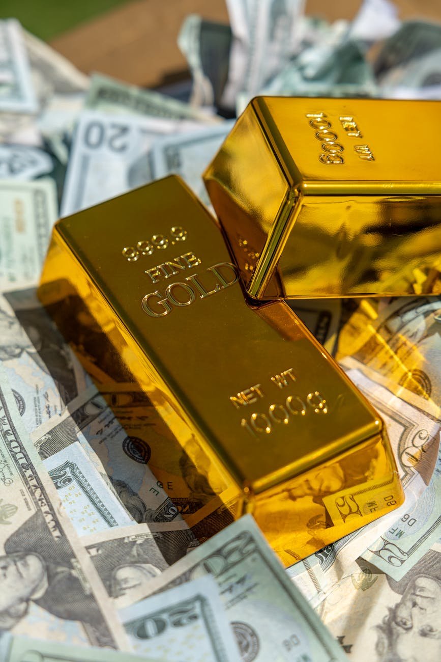shiny gold bars on piles of us dollars