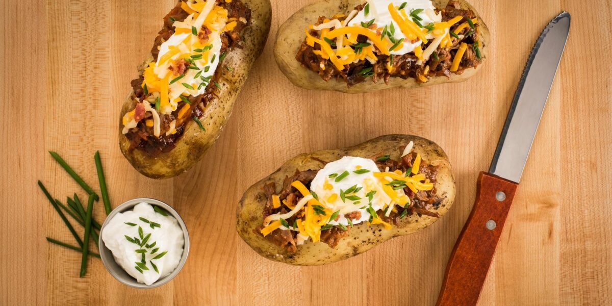 delicious loaded baked potatoes on wood surface