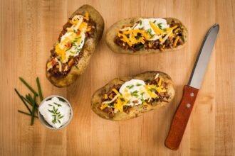 delicious loaded baked potatoes on wood surface