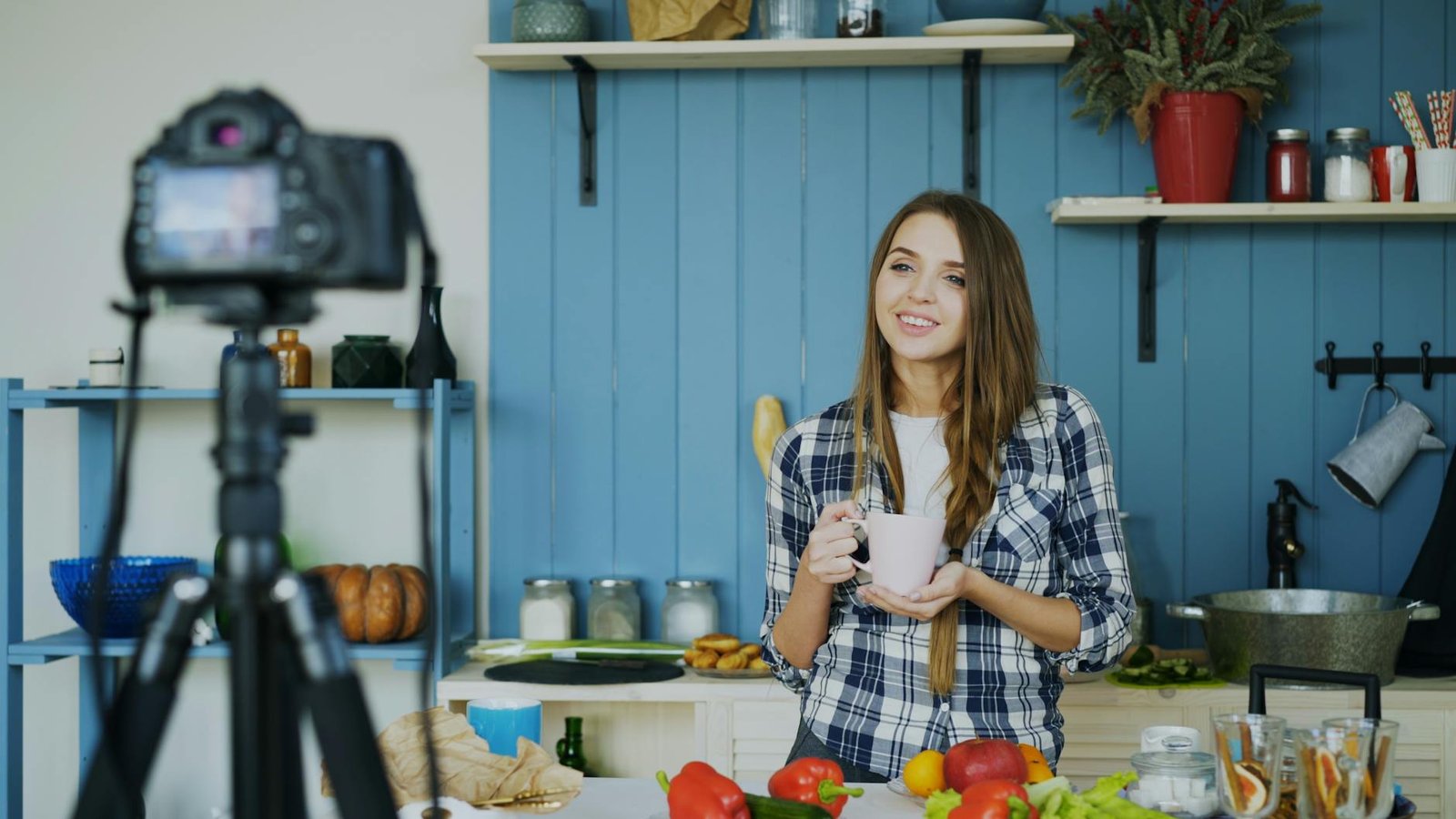 young woman filming cooking video in kitchen