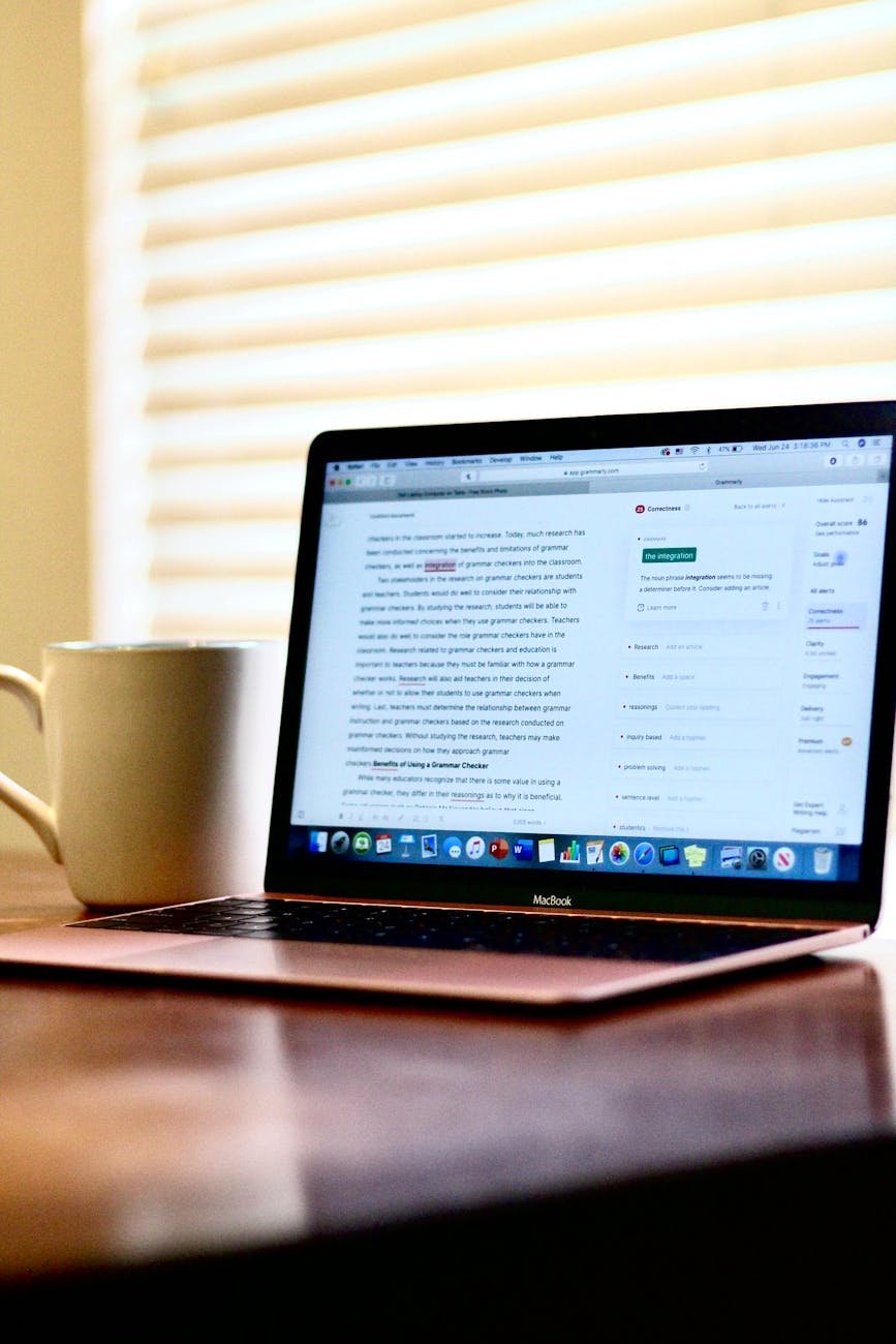 illuminated laptop beside white ceramic mug