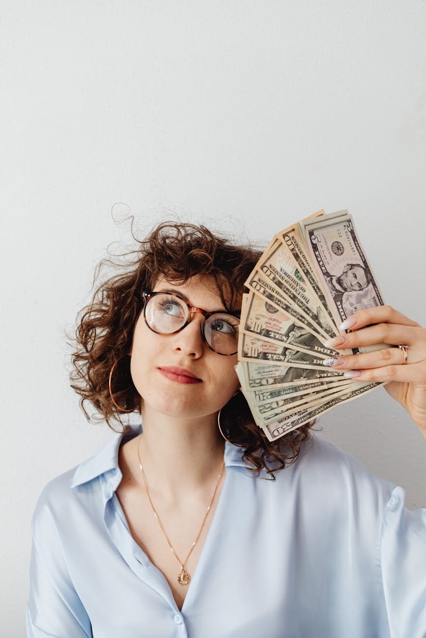 curly haired woman holding paper money