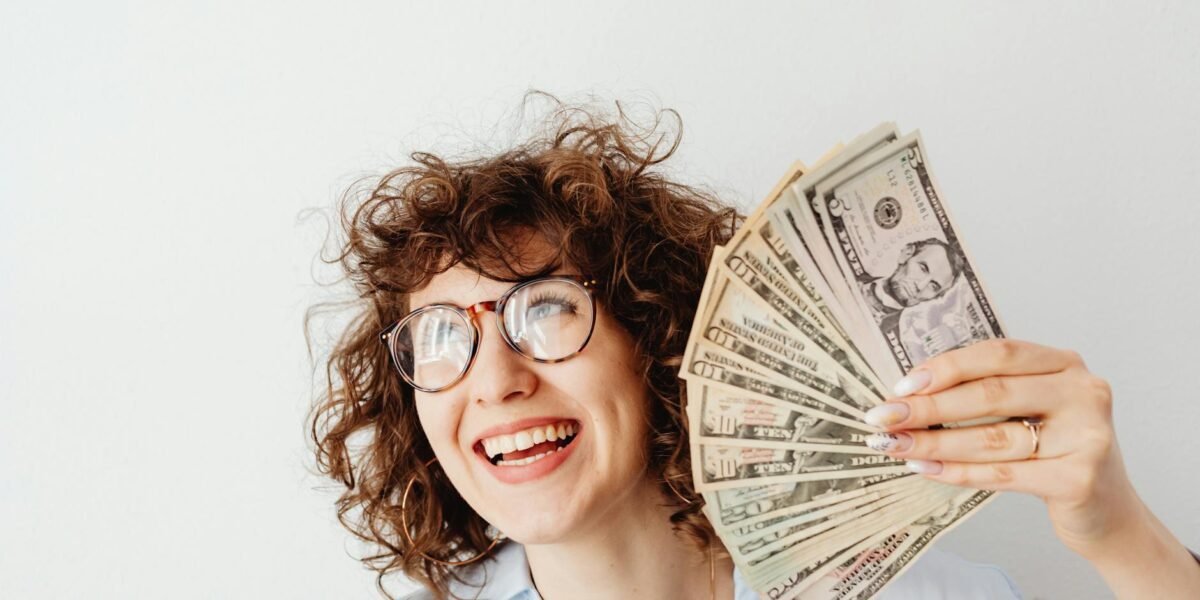 a woman holding us dollar bills