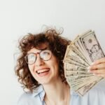 a woman holding us dollar bills
